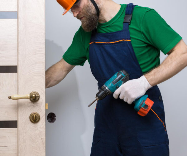 male-locksmith-installs-door-apartment-guy-works-with-screwdriver (1)